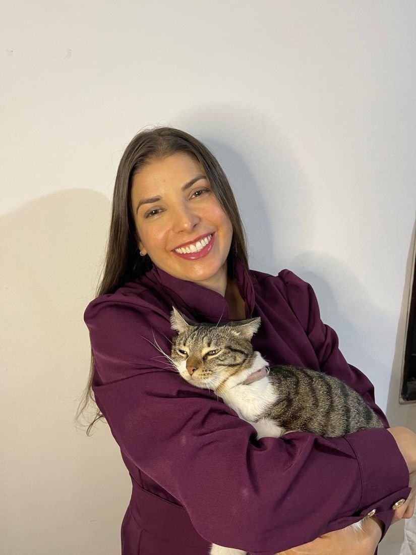 Dra. Sara Burrini segurando um gato tranquilo no colo