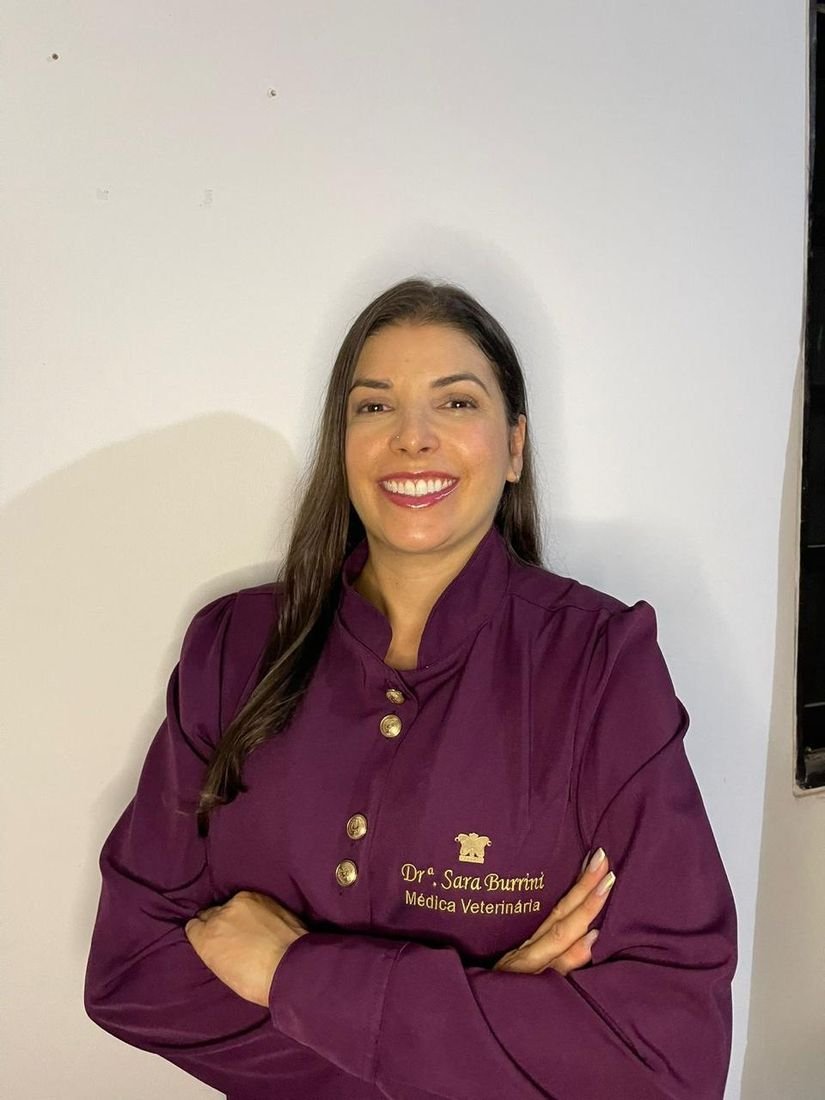 Dra. Sara Burrini de jaleco bordô, sorrindo